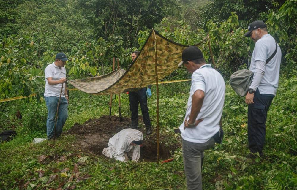 Un grupo personas trabajando en la recuperación de un cuerpo este sábado, en Apartadó (Colombia).