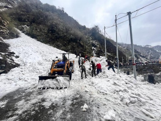 Un grupo de personas con palas y maquinaria intenta rescatar a víctimas sepultadas por una avalancha, este martes en Sikkim, India.