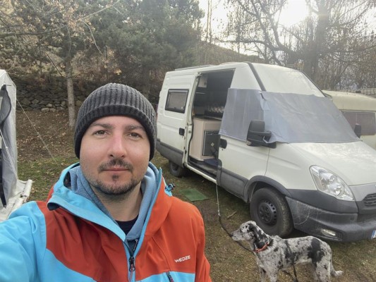 Óscar Fernández Quiles se toma una foto junto a la furgoneta en la que vive.