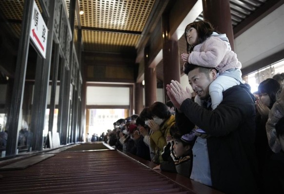 Un padre y su hijo ofrecen oraciones de Año Nuevo en el templo Naritasan Shinshoji en Narita, al este de Tokio, Japón, el 1 de enero de 2024.