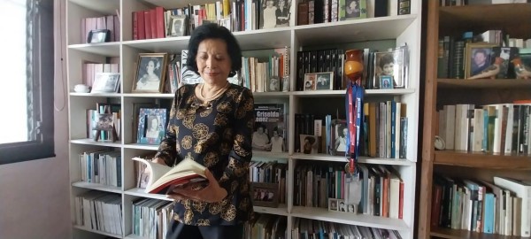 Griselda López con su inmenso estante de obras literarias.
