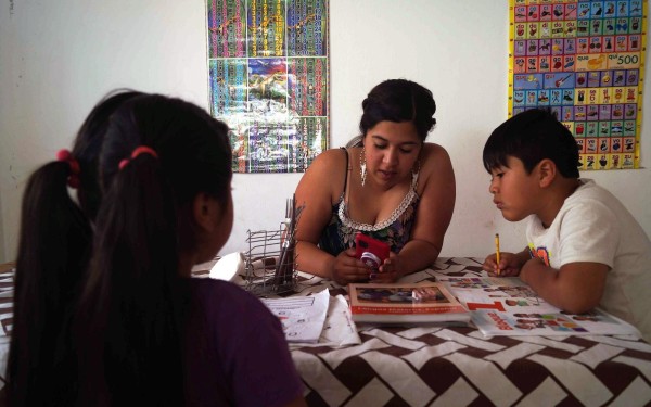 La mexicana Daniela Lizet Villegas (c) acompaña a sus hijos Carlos e Isabela en sus tareas el 2 de febrero de 2021, en San Cristóbal de las Casas, estado de Chiapas (México).