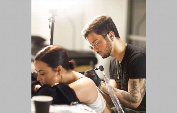 Durante ocho horas le tatúan un ángel a Lovato en la espalda