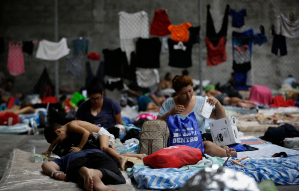Personas migrantes de origen venezolano, incluidos niños, descansan en un refugio temporal, en Ciudad de Panamá.