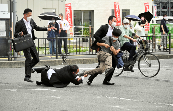Agentes de seguridad mientras detienen al supuesto agresor de Shinzo Abe, muerto hoy por disparos en Nara.