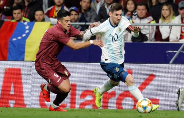Leo Messi (d) lucha con Júnior Moreno, de Venezuela.
