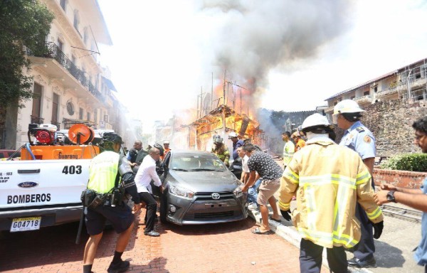 Obreros, policías y bomberos cargaron los autos para sofocar el incendio.