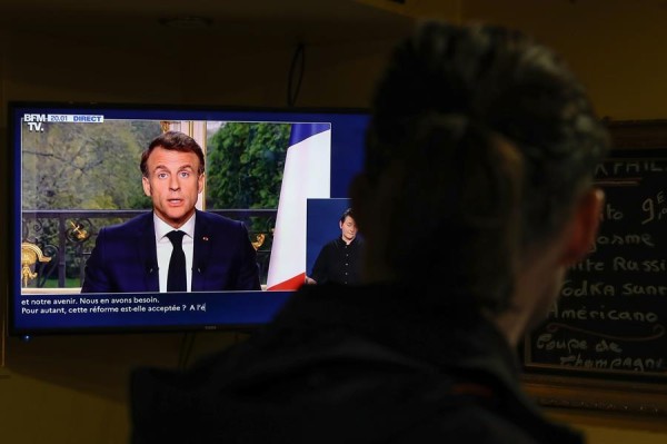 Un hombre observa la intervención en televisión del presidente de Francia, Emmanuel Macron, para dirigirse al país en medio de la crisis política por la aprobación de la reforma de las pensiones.