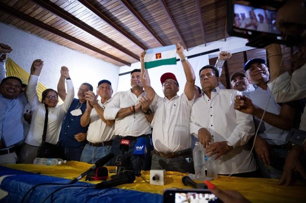 El candidato opositor a la Gobernación de Barinas -cuna de Hugo Chávez, Sergio Garrido (c)-, muestra la bandera del estado.