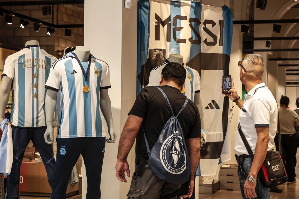 Aficionados de la selección argentina de fútbol acuden a una tienda a comprar la nueva camiseta de la selección con las tres estrellas y el escudo de campeones del mundo, hoy, en Buenos Aires (Argentina).