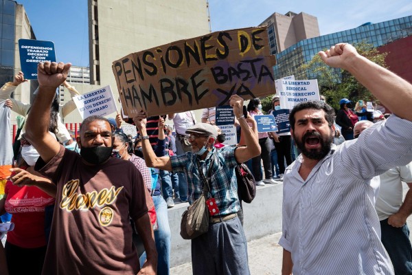 Fotografía de archivo de un hombre mientras carga una pancarta que dice pensiones de hambre, basta ya, junto atrabajadores del sector salud participan en una manifestación para exigir mejores condiciones laborales y salariales en Caracas, Venezuela.