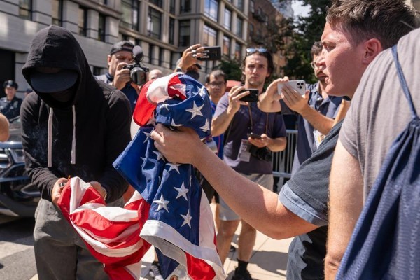Una persona quema la bandera de Estados Unidos durante una protesta frente a la residencia del alcalde de Nueva York, el demócrata Eric Adams, hoy, en Nueva York (Estados Unidos).