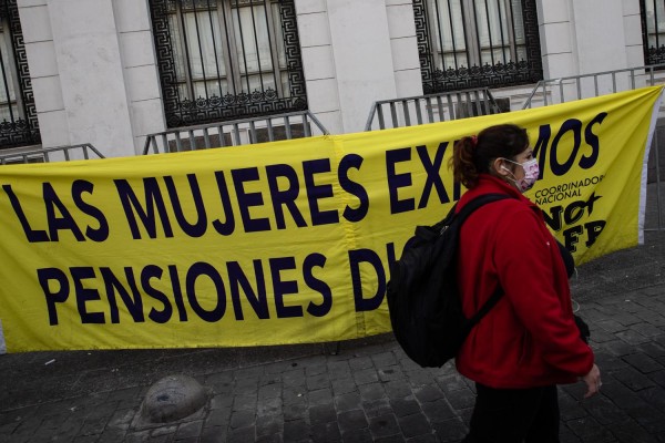 Una mujer pasa frente a un cartel exigiendo pensiones dignas durante una protesta convocada por diferentes organizaciones en Santiago Chile el pasado abril.