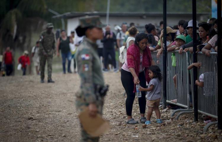 Una migrante con una niña esperan en una estación de recepción migratoria luego de cruzar la selva del Darién con rumbo a los Estados Unidos, el 10 de abril de 2024, en Lajas Blancas (Panamá).