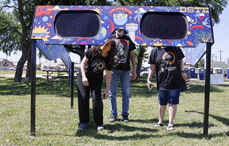 Una familia mira a través de un par de gafas gigantes especiales para el eclipse solar (EE.UU).