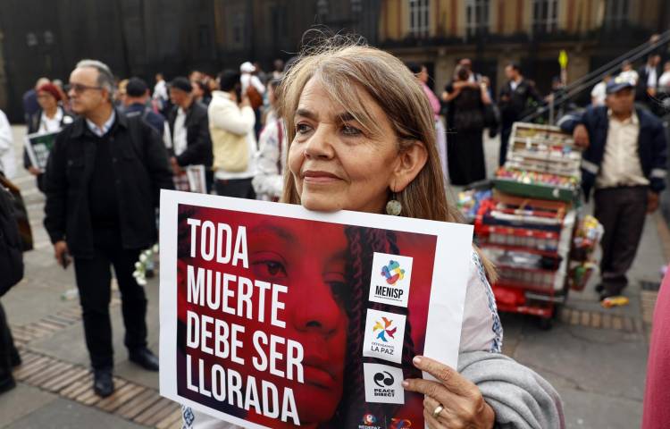 Fotografía de archivo del 20 de febrero de 2024 de una persona que sostiene un cartel de protesta durante una manifestación contra los asesinatos de los firmantes de paz de las FARC y líderes sociales en el país, en Bogotá (Colombia).