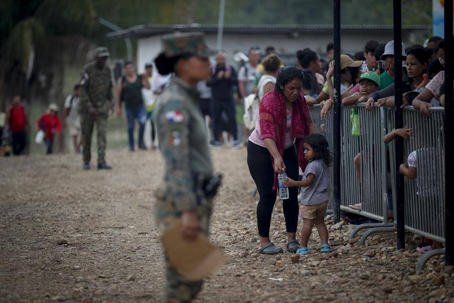 Una migrante con una niña esperan en una estación de recepción migratoria luego de cruzar la selva del Darién con rumbo a los Estados Unidos, el 10 de abril de 2024, en Lajas Blancas (Panamá).