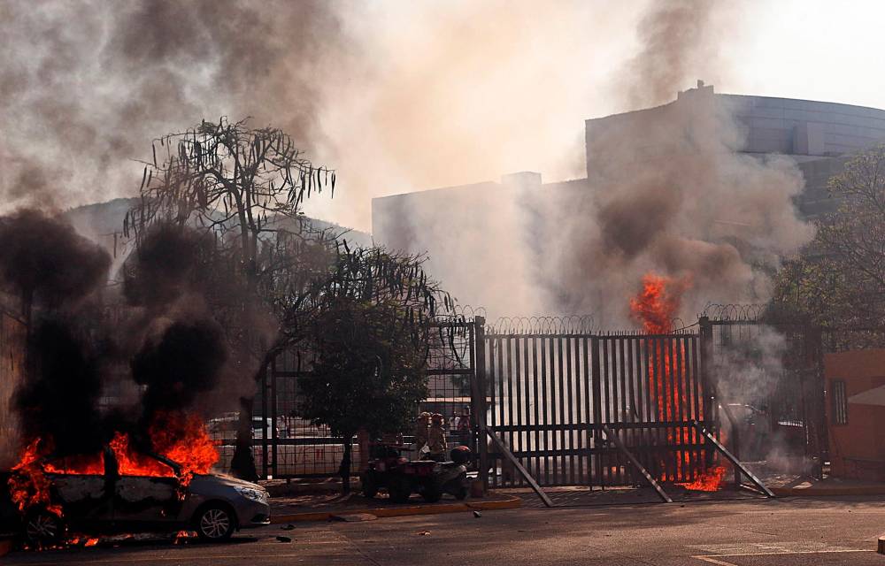 Vehículos incendiados en el interior del Palacio de Justicia durante la protesta estudiantil.