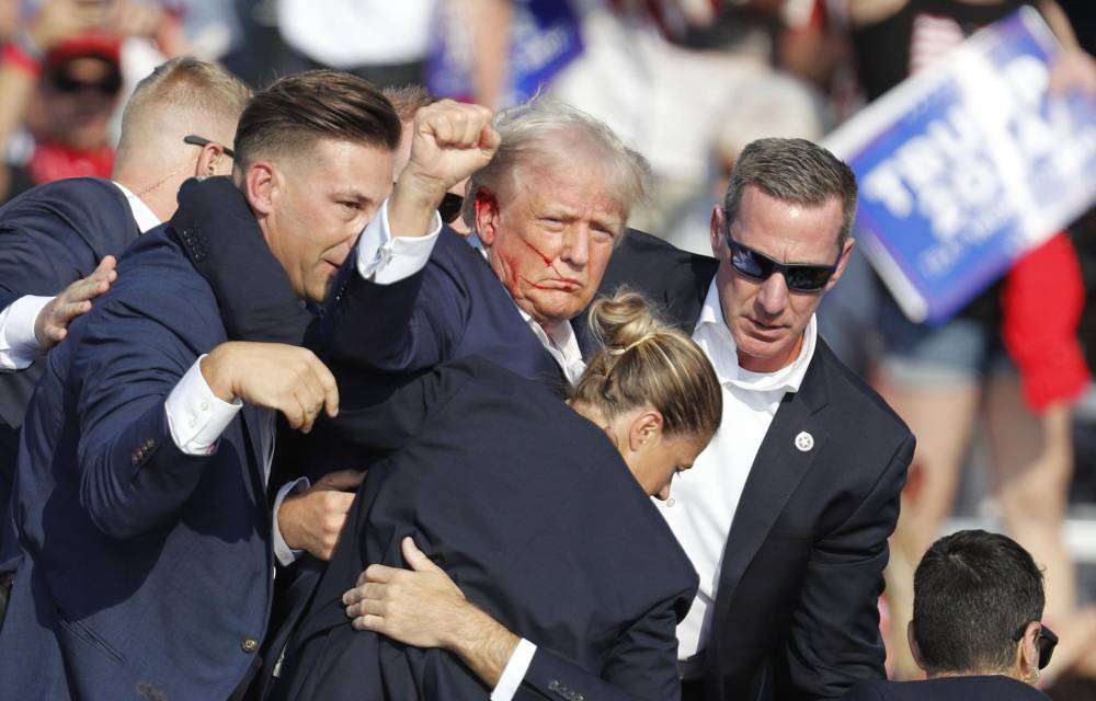 El expresidente estadounidense y candidato republicano Donald Trump con el puño en alto y la cara ensangrentada tras ser alcanzado este sábado por un disparo durante un mitin en Butler (Pensilvania).