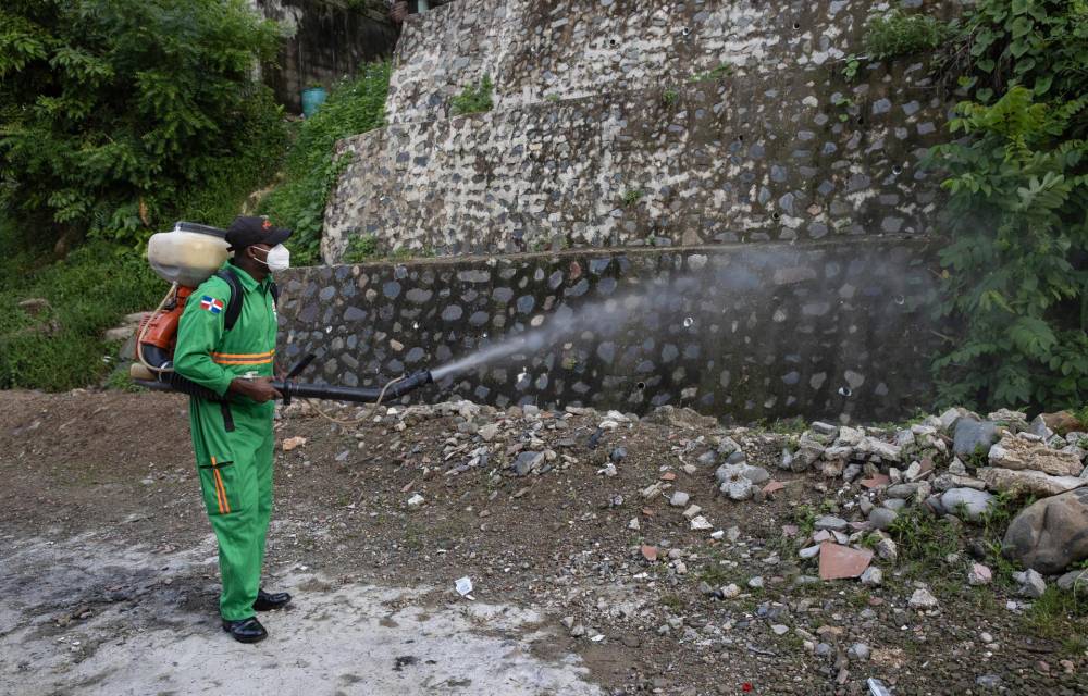 Un integrante de la Comisión Militar y Policial fumiga para eliminar criaderos del mosquito transmisor del dengue en Santo Domingo (República Dominicana).