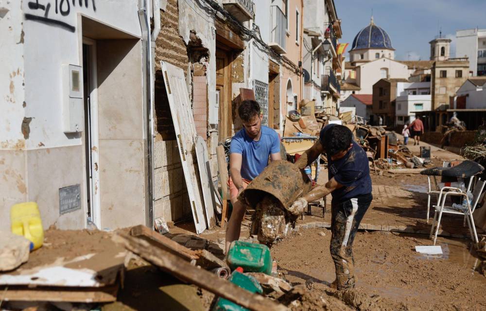 Vecinos de Chiva limpian sus hogares tras la DANA que asolado el sureste español y ha causado más de un centenar de muertos, este jueves.