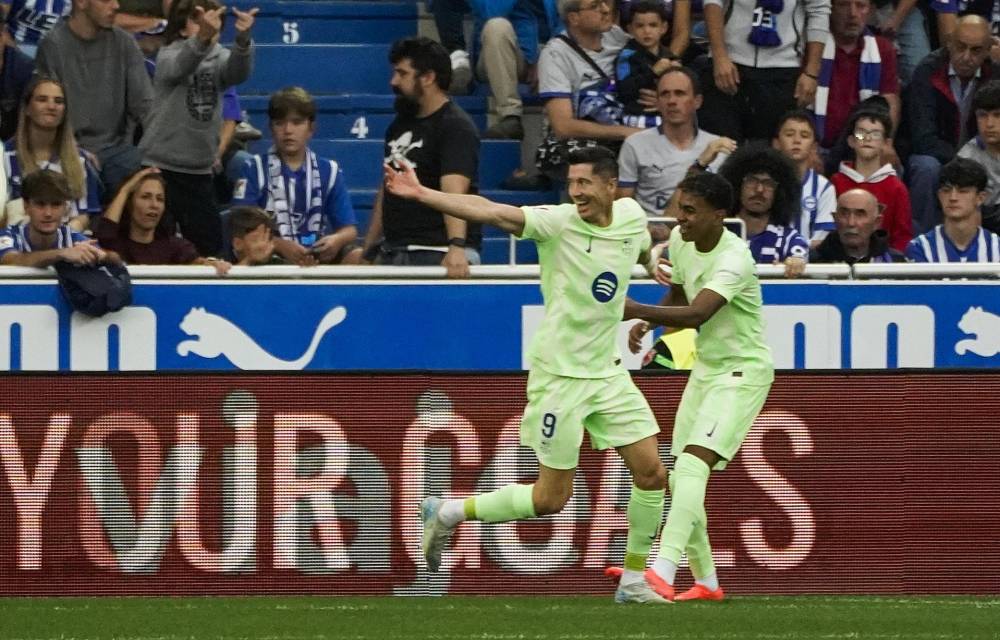 El delantero polaco del FC Barcelona Robert Lewandowski celebra con Lamine Yamal (d) el gol marcado ante el Alavés durante el partido de la novena jornada de Liga en el estadio de Mendizorrotza de Vitoria. EFE/L. Rico