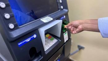 Imagen de un jubilado retirando su dinero en un cajero electrónico.