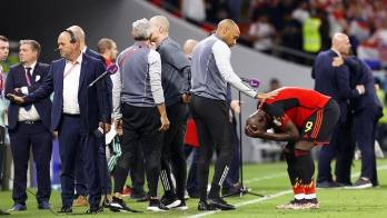 El técnico asistente de Bélgica, Thierry Henry, trata de consolar al delantero Romelu Lukaku.