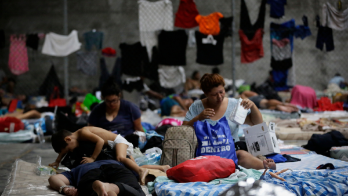 Personas migrantes de origen venezolano, incluidos niños, descansan en un refugio temporal, en Ciudad de Panamá.