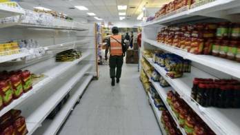 Oficinistas hacen una fila frente a tiendas de víveres en Caracas para comprar un almuerzo lo más barato posible.