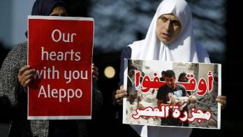 Mujeres árabes sostienen pancartas en apoyo a las víctimas de los bombardeos