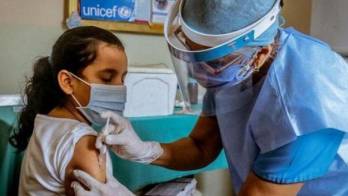 Niña recibe dosis contra el papiloma humano.