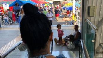 En la estación del metro en Los Pueblos, una mujer junto a sus dos niños pasa el día sentada en el piso.