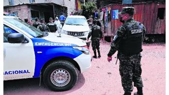 Policías vigilan una casa donde ocurrió un asesinato.