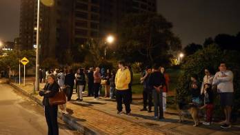 Residentes de un edificio salen de sus viviendas tras sentir un sismo en la madrugada de hoy, en Bogotá (Colombia).