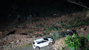 Restos de vehículos y lodo en el lugar donde ocurrió el derrumbe.