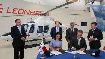 Firma del acuerdo y el helicóptero al fondo.
