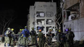 Personal de seguridad, rescate y paramédicos israelíes trabajan en el lugar del impacto directo de un misil iraní en Arad, Israel, el 21 de marzo de 2026. Según un portavoz del servicio de ambulancias Magen David Adom (MDA), 75 personas recibieron atención médica y fueron trasladadas a hospitales.