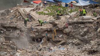 Personas remueven escombros de un edificio colapsado por los terremotos del 24 junio. EFE/ Ronald Peña R