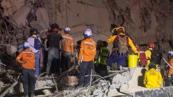 Integrantes de equipos de rescate trabajan en un edifico afectado por el terremoto en Venezuela.