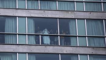 Personas miran desde una ventana del hotel Decápolis este martes, en Ciudad de Panamá (Panamá).