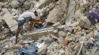 Una persona busca entre los escombros de edificios destruidos por terremotos en Caraballeda (Venezuela). EFE/ Miguel Gutiérrez