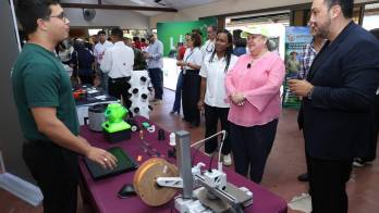 Jóvenes mostrando sus proyectos de robótica o inteligencia artificial.