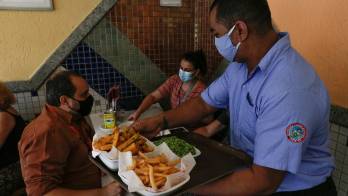 Un camarero atiende a clientes en un restaurante, en Río de Janeiro, en una fotografía de archivo.
