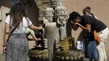 Varias personas se refrescan en una fuente en Roma, Italia.