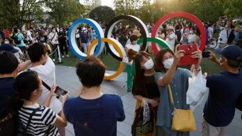 Varios curiosos se congregan delante del Estadio Olímpico, en Tokio.