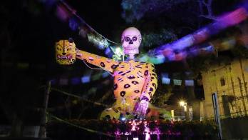 Visitantes observan figuras de calaveras gigantes, el 20 de octubre de 2022, en las calles del municipio de Atlixco, estado de Puebla (México).