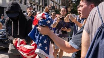 Una persona quema la bandera de Estados Unidos durante una protesta frente a la residencia del alcalde de Nueva York, el demócrata Eric Adams, hoy, en Nueva York (Estados Unidos).