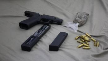 Una de las armas de fuego con su proveedor y municiones decomisados durante el operativo en Santa Ana.