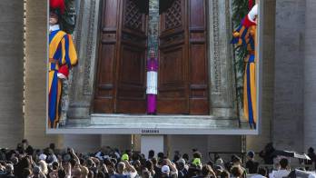 La pantalla gigante transmite imágenes del cierre de la puerta de la Capilla Sixtina, al inicio del cónclave para elegir al nuevo Papa, en la Plaza de San Pedro del Vaticano.